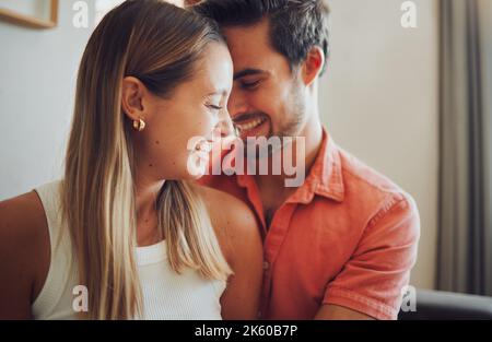 Nahaufnahme eines lustigen jungen kaukasischen Paares, das die Köpfe berührt und lacht und glücklich aussieht, zusammen zu sein, während es Zeit zu Hause verbringt. Liebevolles Lächeln Stockfoto