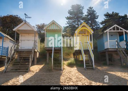 Bunte hölzerne Strandhütten am Strand in Wells Next the Sea in North Norfolk, Großbritannien Stockfoto