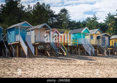 Bunte hölzerne Strandhütten am Strand in Wells Next the Sea in North Norfolk, Großbritannien Stockfoto