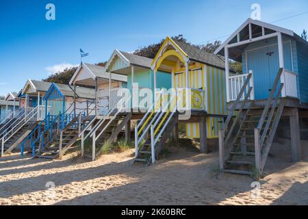 Bunte hölzerne Strandhütten am Strand in Wells Next the Sea in North Norfolk, Großbritannien Stockfoto