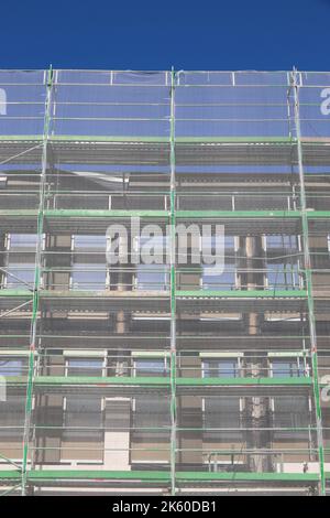 Schutznetze auf Baustellengerüsten. Generischer Bürobau in der deutschen Stadt (Nürnberg in Bayern). Stockfoto