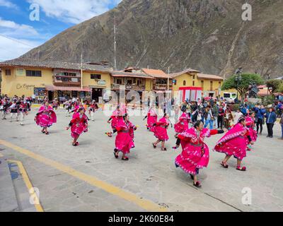 Einheimische Mädchen in traditionellen Kostümen tanzen während eines lokalen Festivals in der Stadt Ollantaytambo, in der Region Urubamba, in den Anden, in Peru. Stockfoto