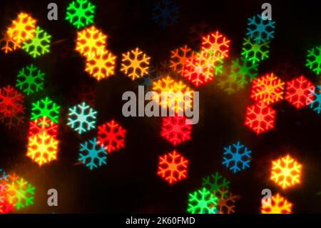 Weihnachten festlichen Hintergrund, verschwommen Weihnachten mehrfarbigen Bokeh Hintergrund. Weihnachten leuchtende Farben Lichter mit Funkeln, verschwommen hellen Abst Stockfoto