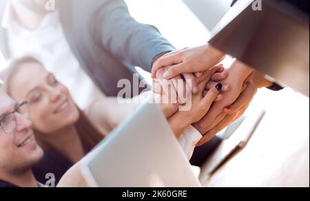 Nahaufnahme. Junge Mitarbeiter machen ihnen einen Turm aus der Hand Stockfoto