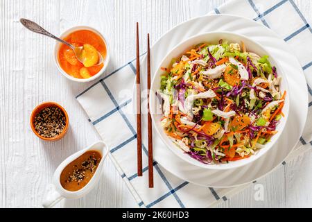 Chinesischer Hühnersalat mit zerfetztem Hühnerfleisch, Mandarinen-Orangen, knusprigen Nudeln, Rotkohl, napa-Kohl, Karotten, grüne Zwiebeln und asiatische Dressi Stockfoto
