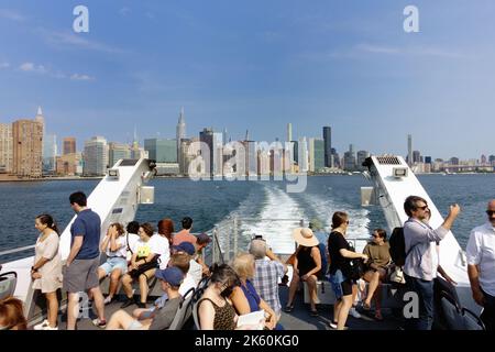 Touristen und Pendler mischen sich auf einer Fähre auf dem East River in New York Stockfoto