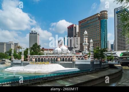 Kuala Lumpur, Malaysia - 4. 2018. Februar: Von Wolkenkratzern überblickt die Jamek-Moschee am Klang-Fluss. Stockfoto