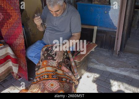 Bergama, Izmir, Türkei - 10.10.2022: Teppichweber, traditioneller handgemachter Teppich Stockfoto