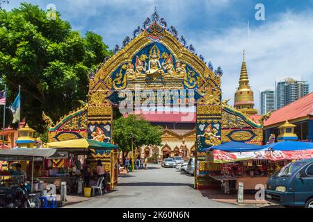 George Town, Penang, Malaysia - 10. 2018. März: Marktstände vor dem goldverzierten Eingang zum thailändischen buddhistischen Tempel Wat Chaiyamangalaram Stockfoto