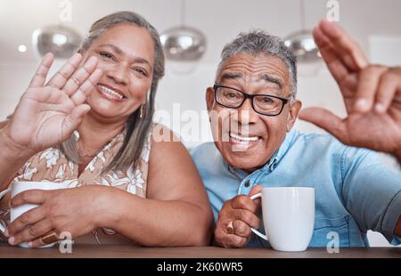 Ältere Paare, Kaffee und Welle für Videoanruf, lächelnd, sprechend oder sprechend zu Hause. Ältere Männer und Frauen grüßen in sozialen Medien oder im Gesicht, während Stockfoto