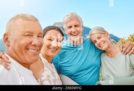 Porträt einer Gruppe älterer Freunde, die zusammen stehen. Lächelnde aktive Senioren, die nach oder vor dem Yoga-Gruppentraining in der Natur zusammenstehen Stockfoto