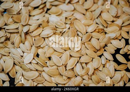 Über das Backblech geröstete Kürbiskerne in Schale gestreut Stockfoto