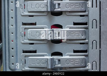 Sehr verschmutzte Verriegelungen für die Verriegelungen „Lock and Open“ (Verriegeln und Öffnen) sind geschlossen. Schalter im Fach für Festplatten, HDD- und SSD-Laufwerke, DVD- und CD-Laufwerke Stockfoto