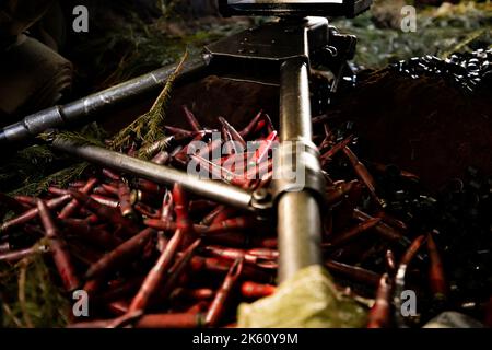 Nahaufnahme Soldaten feuern eine 50 Cal Machine Kanone mit verbranntem Messing um sie herum Stockfoto