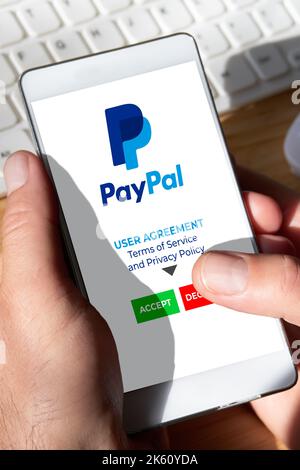 PayPal-Nutzervereinbarung Ablehnung, Kontostornierung. Smartphone-Nutzer lehnt es ab, die Nutzungsbedingungen und die Datenschutzrichtlinie der mobilen App von PayPal zu akzeptieren. Stockfoto