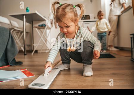 Zwei Kinder helfen ihren Eltern, die Küche zu reinigen Stockfoto