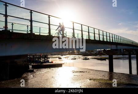 Shoreham , Brighton Großbritannien 11. October 2022 - Es ist ein schöner sonniger Tag in Shoreham-by-Sea, während die Menschen über die Fußgängerbrücke über den Fluss Adur wandern und radeln. : Credit Simon Dack / Alamy Live News Stockfoto