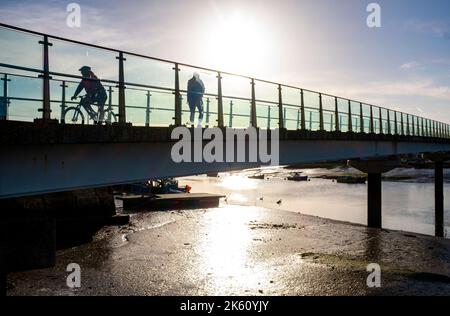 Shoreham , Brighton Großbritannien 11. October 2022 - Es ist ein schöner sonniger Tag in Shoreham-by-Sea, während die Menschen über die Fußgängerbrücke über den Fluss Adur wandern und radeln. : Credit Simon Dack / Alamy Live News Stockfoto