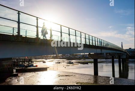 Shoreham , Brighton Großbritannien 11. October 2022 - Es ist ein schöner sonniger Tag in Shoreham-by-Sea, während die Menschen über die Fußgängerbrücke über den Fluss Adur wandern und radeln. : Credit Simon Dack / Alamy Live News Stockfoto