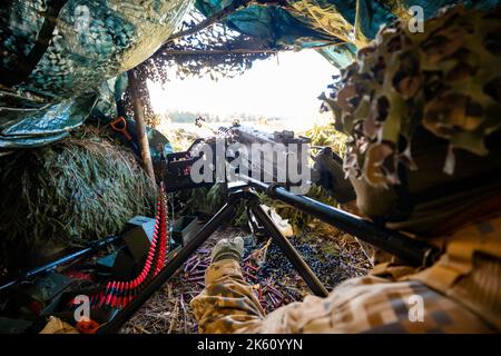 Nahaufnahme Soldaten feuern ein 50 Cal Maschinengewehr mit verbranntem Messing um ii Stockfoto