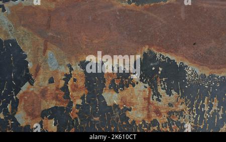 Brauner Rostfleck auf der schwarzen mit blau mit grün mit grau und silberfarben Oberfläche des Blechs, rissige und abblätternde Oberflächen Stockfoto