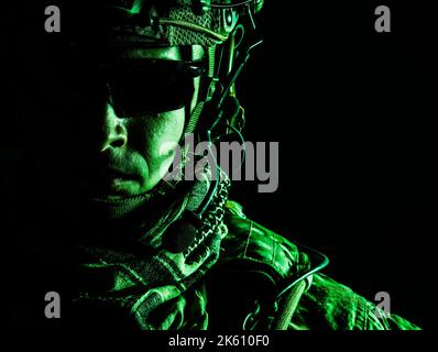 Elite-Mitglied der US Army Ranger in Kampfhelm und dunkler Brille. Studioaufnahme, dunkelschwarzer Hintergrund, Blick auf die Kamera, dunkler Kontrast, getönt und farbig Stockfoto