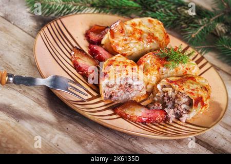 Sarma - traditionelle Balkan- und osteuropäische Urlaubskost - Zusammengerollte Kohlblätter gefüllt mit Reis und Hackfleisch (Selektiver Fokus) Stockfoto