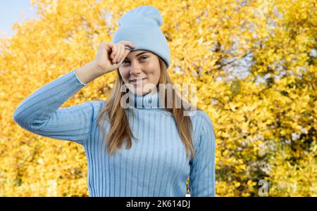 Porträt einer glücklichen Frau auf gelben Herbstblättern Hintergrund. Foto von einem positiven fröhlichen Mädchen genießen Herbst Freizeit in der Innenstadt, im Park, in Stockfoto