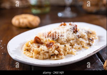 Risotto mit Steinpilzen.typisch italienische Küche weißer Reis mit Pilzen in Parmesan-Sauce. Antipasto zum Abendessen. Speicherplatz kopieren Stockfoto