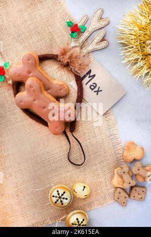 Hundefreuden für ein fantastisches Weihnachtsgeschenk für Haustiere. Rustikales Flach-Lay mit Eiswürmchen und Klingeln Stockfoto