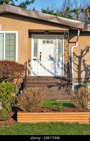 Haupteingang des Wohnhauses mit Türstufen an sonnigen Tag im Winter. Stockfoto