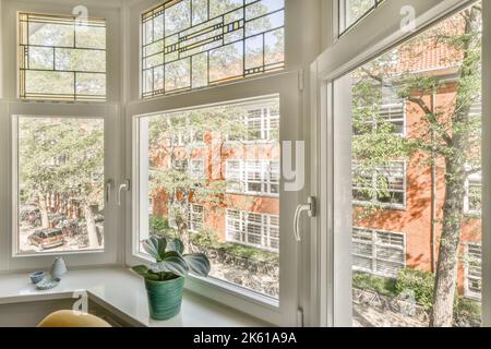 Runde Dekorationen und Pflanzen in Topf auf Fensterbank im hellen Raum der modernen Wohnung platziert Stockfoto