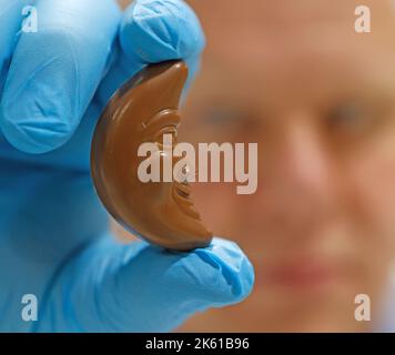 Wernigerode, Deutschland. 11. Oktober 2022. Ansicht einer Schokoladenfigur für einen Adventskalender. Die Produktion des Weihnachtskalenders befindet sich derzeit in der Endphase. Die Adventskalender und Weihnachtsschokoladen aus Wernigerode haben eine lange Tradition und werden in viele Länder exportiert. Quelle: Matthias Bein/dpa/Alamy Live News Stockfoto