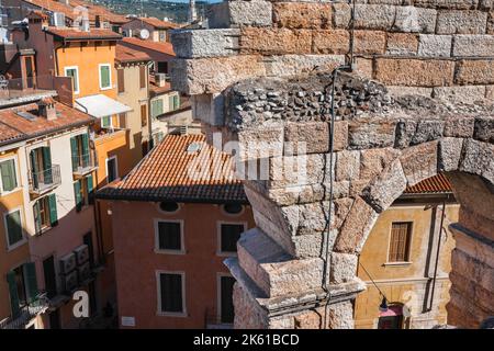 Verona Italien Architektur, kontrastierende Blick im Sommer auf einen zerstörten Abschnitt der römischen Arena und Häuser in der Via Anfiteatro im Zentrum von Verona Stockfoto