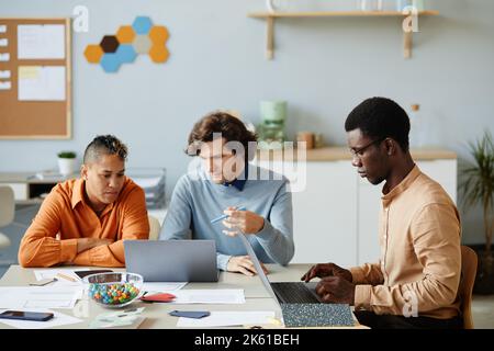 Porträt eines vielfältigen Geschäftsteams, das Laptops in IT-Entwicklungsbüros verwendet und während des Meetings zusammenarbeitet Stockfoto