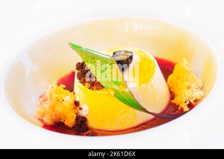 Panna Cotta Dessert mit rotem Sirup und Schokoladentrüffel (Selektiver Fokus) Stockfoto