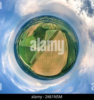 Luftaufnahme aus großer Höhe des kleinen Planeten Erde mit grünen und gelben bebauten landwirtschaftlichen Feldern mit wachsenden Kulturen an hellen Sommertag Stockfoto