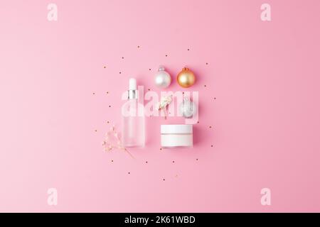 Weihnachts-Display für kosmetische Produkte. Hautpflegeprodukte auf rosa Hintergrund. Flach liegend, Kopierplatz Stockfoto