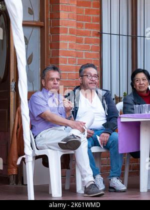La Paz, Bolivien - 10 2022. September: Bolivianischer Mann, der ein Lilac-Hemd trägt, schaut sich die Kindershow an Stockfoto