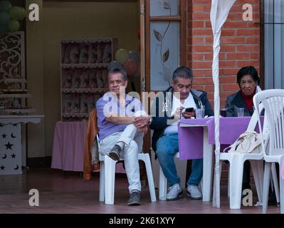 La Paz, Bolivien - 10 2022. September: Bolivianischer Mann, der ein Lilac-Hemd trägt, schaut sich die Kindershow an Stockfoto