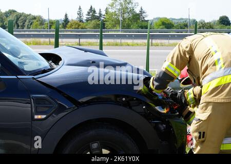 Das Rettungsteam der Ankunft auf der Unfallstelle des Autoabsturzverkehrs. Eilen Sie sich, um verletzten, gefangenen Menschen zu helfen Stockfoto