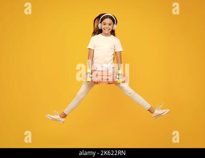 Teenager Lifestyle, lässige Jugendkultur. Teen Mädchen mit Skateboard über isoliert Studio Hintergrund. Springt und lauft. Cool modernen Teenager in stilvoll Stockfoto