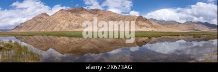 Panoramablick auf die Bergspiegelung in der farbenfrohen Höhenwüste auf dem Pamir Highway , Gorno-Badakshan, Tadschikistan entlang der chinesischen Grenze Stockfoto