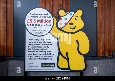 Pudsey trägt Schild an der Autobahn Fleet Services M3, Welcome Break Service, der den Menschen dafür dankt, dass sie Millionen Pfund für BBC Children in Need aufgestossen haben Stockfoto