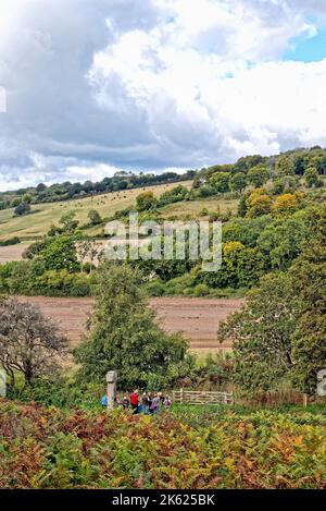 Eine Gruppe älterer Wanderer, die an einem Herbsttag in der Nähe von Dorking England am Samuel Wilberforce Memorial in Abinger Roughs in den Surrey Hills stehen Stockfoto