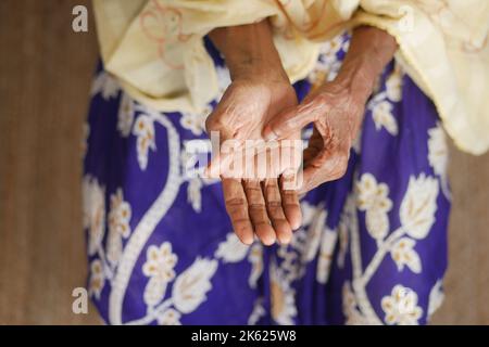 Ältere asiatische Frau, die an Schmerzen leidet Stockfoto