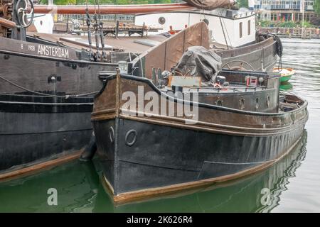 Niederlande. Sommertag in Amsterdam. Kahn und Boot, über 100 Jahre alt, vertäuten sich gegenseitig Stockfoto