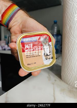Paris, Frankreich - Sep 13, 2022: POV männliche Hand halten Pack mit Fit und Fun Wet Pate Katzenfutter Gelee mit Chiken Fleisch und Aloe Vera - moderne Küche Hintergrund Vorbereitung auf das Haustier Katzentier zu füttern Stockfoto