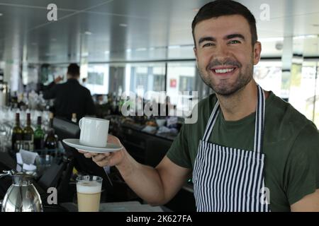 Barista serviert eine Kaffeetasse Stockfoto