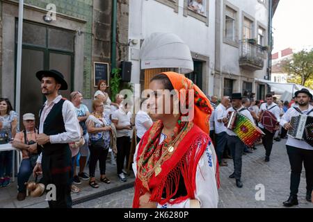 Ponte de Lima - 10. September 2022: Junge Menschen in den traditionellen Kostümen Nordportugals bei der Feiras Novas Festparade. Stockfoto